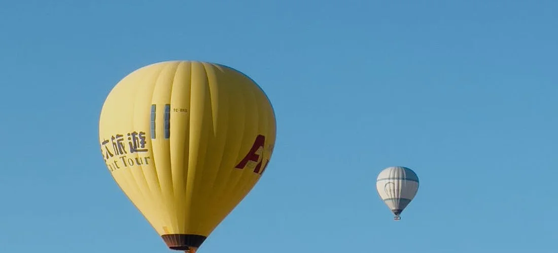 Two hot air balloons floating in a clear blue sky.