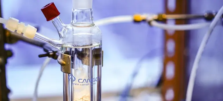 Close-up of laboratory glassware and tubing used to illustrate chemical treatment for hot tub water, related to chlorine to bromine conversion