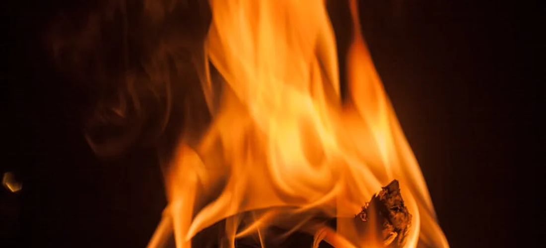 Close-up of bright orange flames burning in a dark background