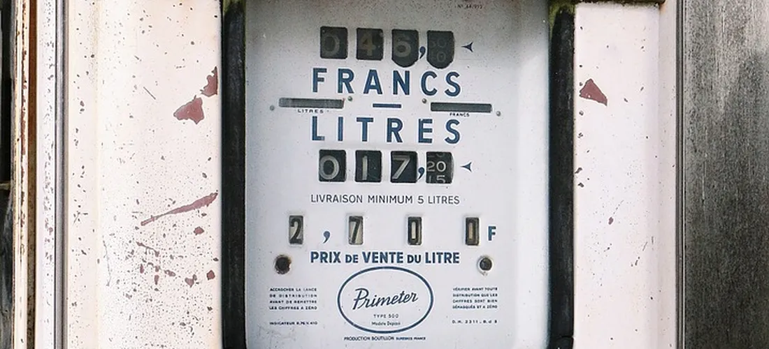 Close-up of a vintage meter with the word 'FRANCS' and 'LITRES' visible, showing numeric dials and French text.