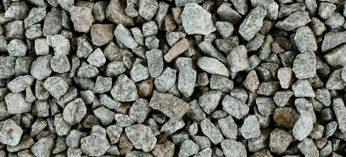 Close-up of assorted gray gravel stones forming a rough base suitable for starting a hot tub installation.