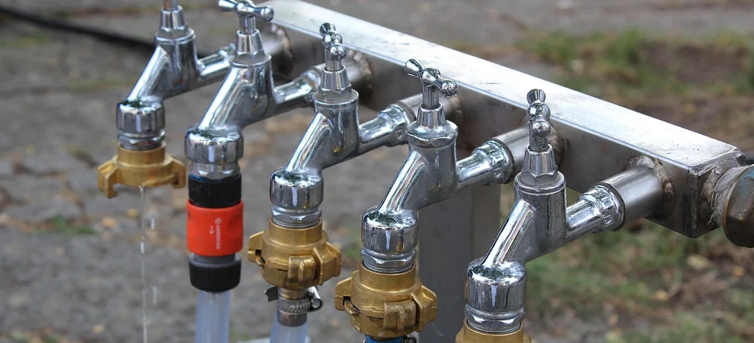 Close-up of a hot tub air control valve manifold with multiple chrome valves and brass fittings