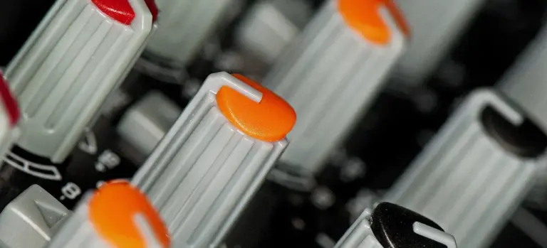 Close-up of a hot tub control panel with gray knobs and orange and black caps