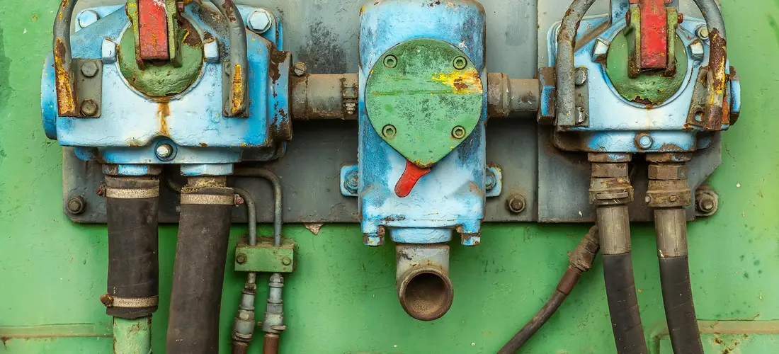Close-up of blue diverter valve assemblies mounted on a green panel with attached hoses