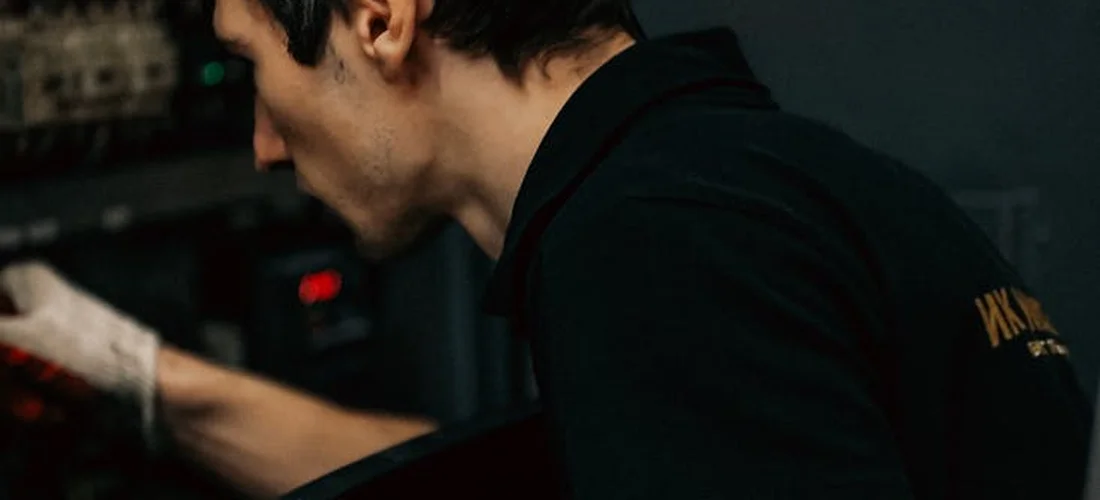 Technician inspecting a hot tub control panel during maintenance