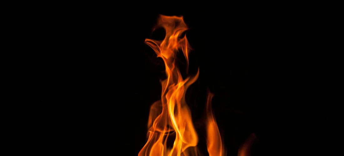 Orange flames rising against a black background, highlighting fire safety considerations around a hot tub area.