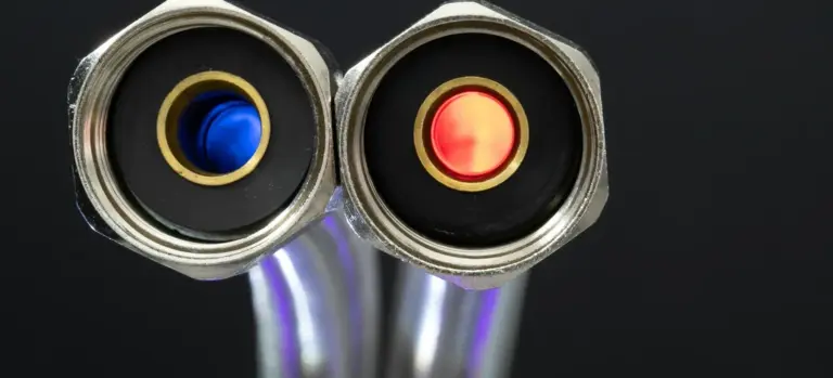 Close-up of hot tub plumbing fittings with blue and red valve caps