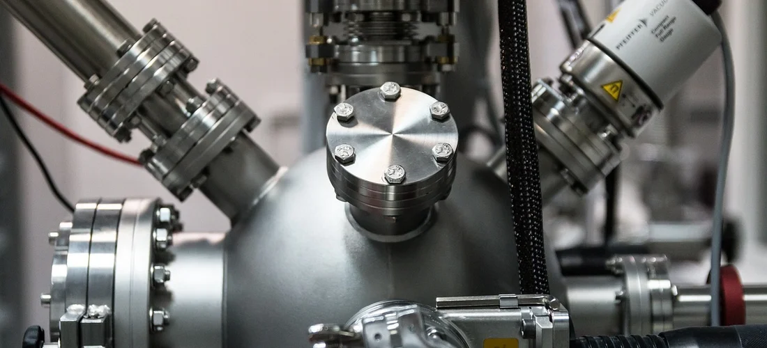 Close-up of a hot tub pump assembly with metal piping and fittings