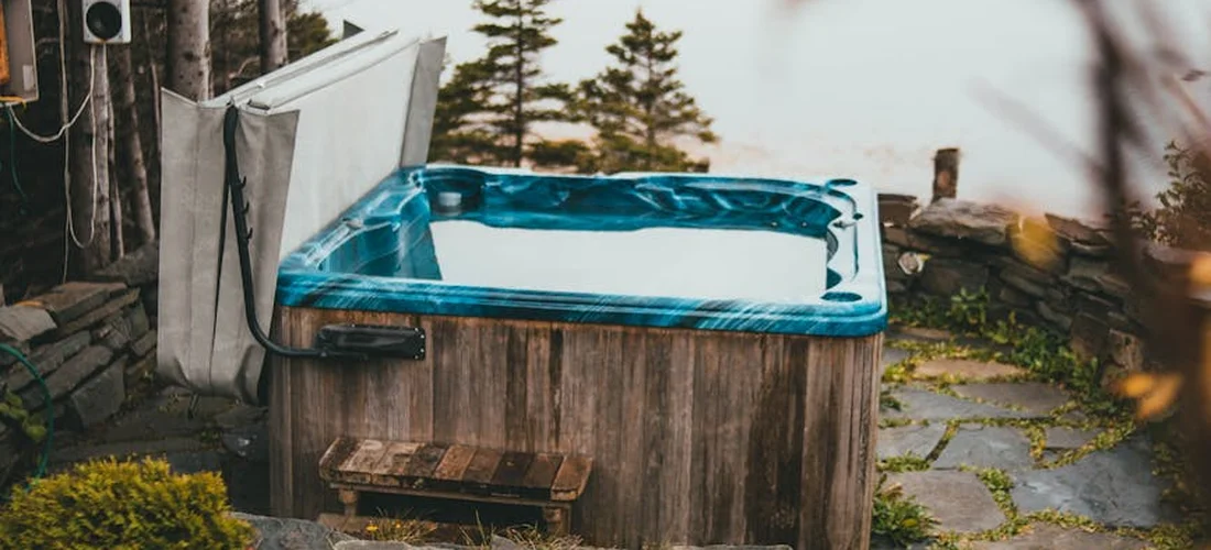Outdoor hot tub on a wooden deck with a cover positioned nearby, illustrating the setup for accurate length, width, and height measurements.