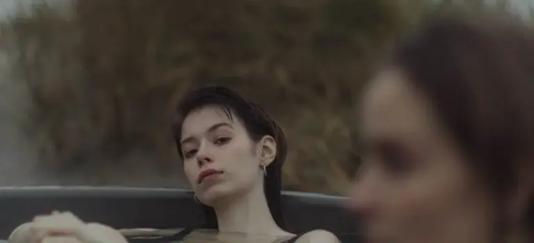 A person relaxing in a hot tub with a blurred outdoor background, illustrating user-focused troubleshooting content.