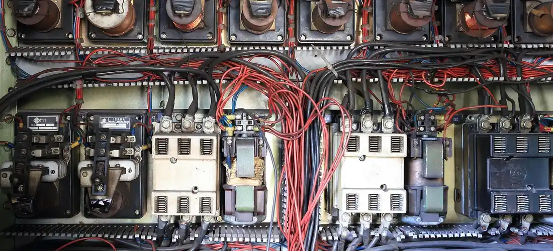 Electrical control panel for a Jacuzzi spa with multiple relays, breakers, and red wiring.
