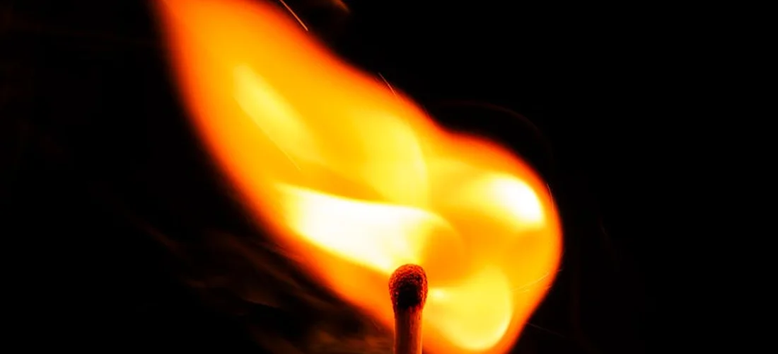 Close-up of a bright orange flame from a match