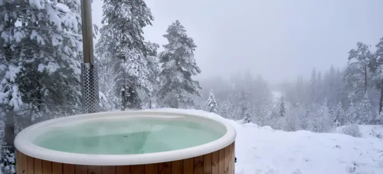 Outdoor wooden Jacuzzi in a snowy forest