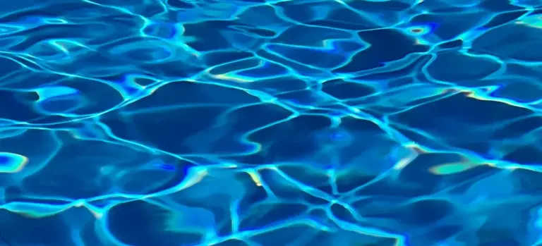 Close-up of blue water surface with light reflections and ripples.
