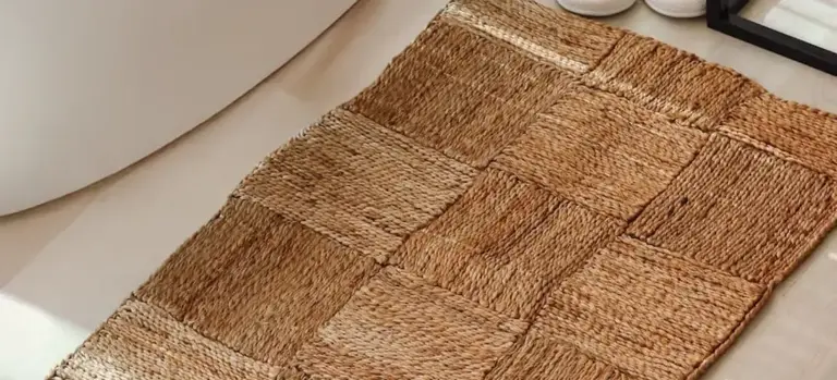 Natural fiber woven bath mat on a tiled bathroom floor near a spa tub, providing a slip-resistant surface.