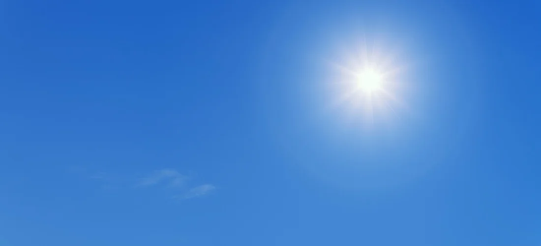 Bright sun in a clear blue sky, symbolizing solar energy calculations for powering a hot tub.